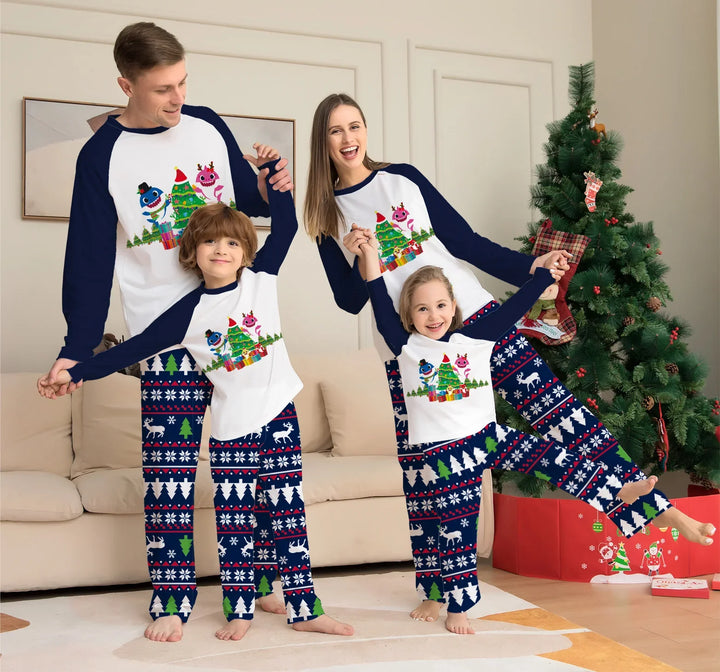Family of four in matching Christmas pajamas with festive patterns and cartoon tree design by decorated Christmas tree