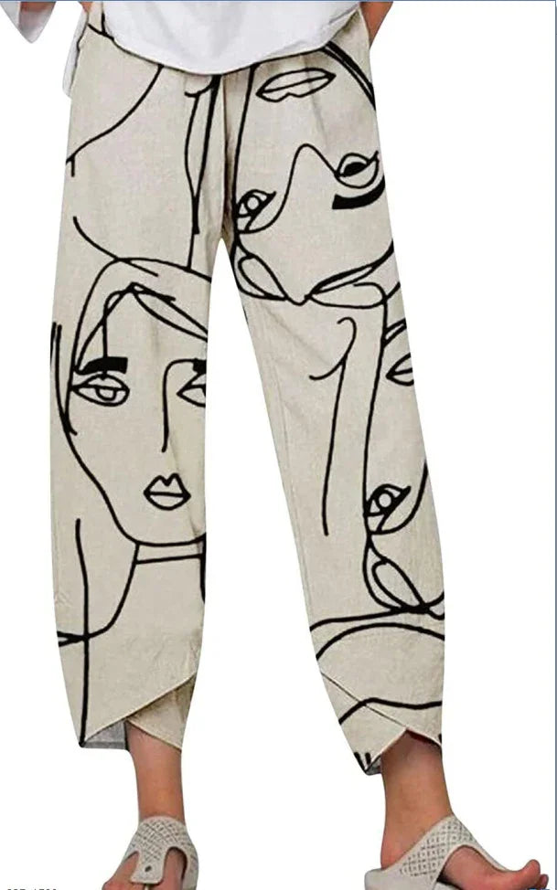 Beige pants with abstract black line art faces, worn with white top and beige sandals