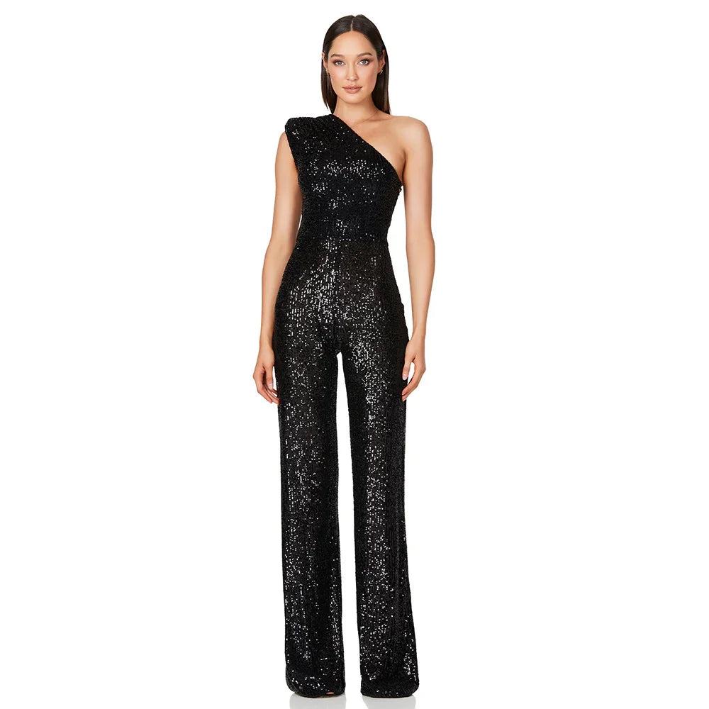 Woman wearing a black one-shoulder sequined jumpsuit with flared pants on white background