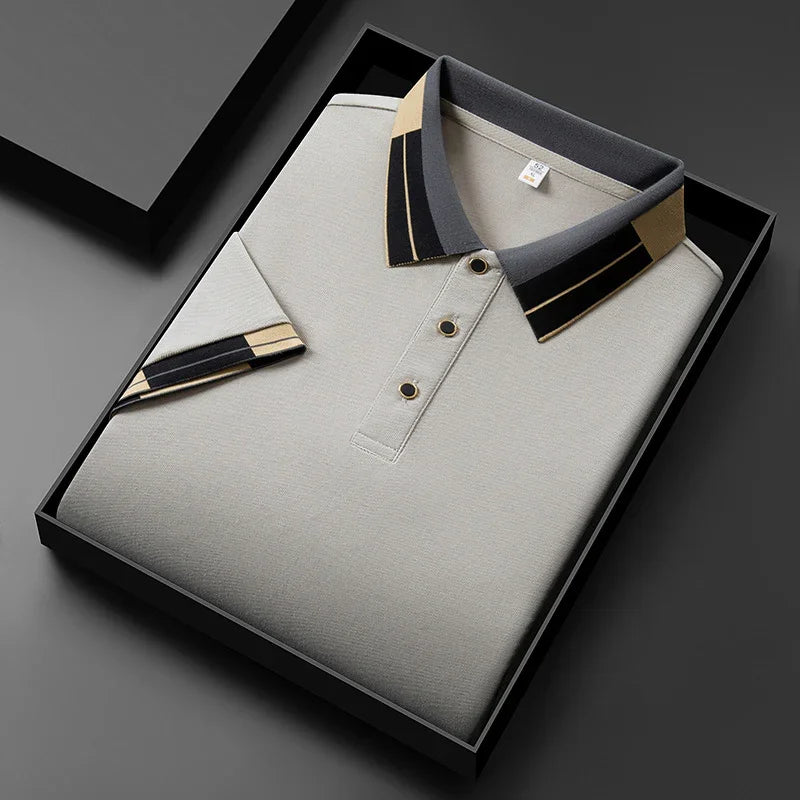 Beige polo shirt with black and tan striped collar and sleeve in black gift box on dark background