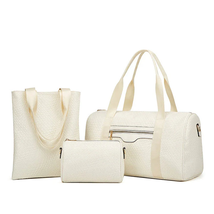 Set of white textured travel duffel bag, tote bag, and small pouch with gold zippers and cream straps