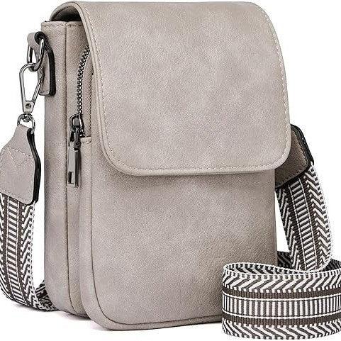 Beige crossbody bag with flap closure and black and white patterned adjustable strap
