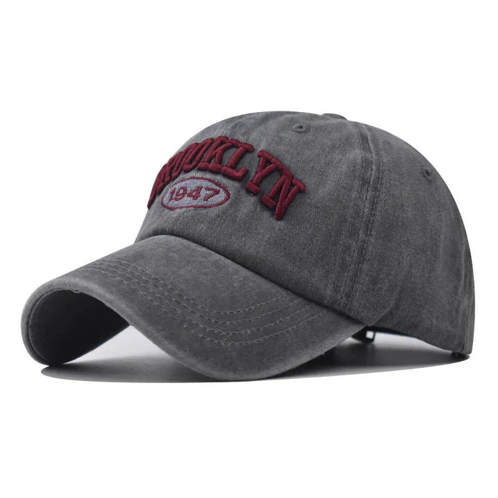 Gray baseball cap with burgundy embroidered Brooklyn 1947 text, vintage casual style