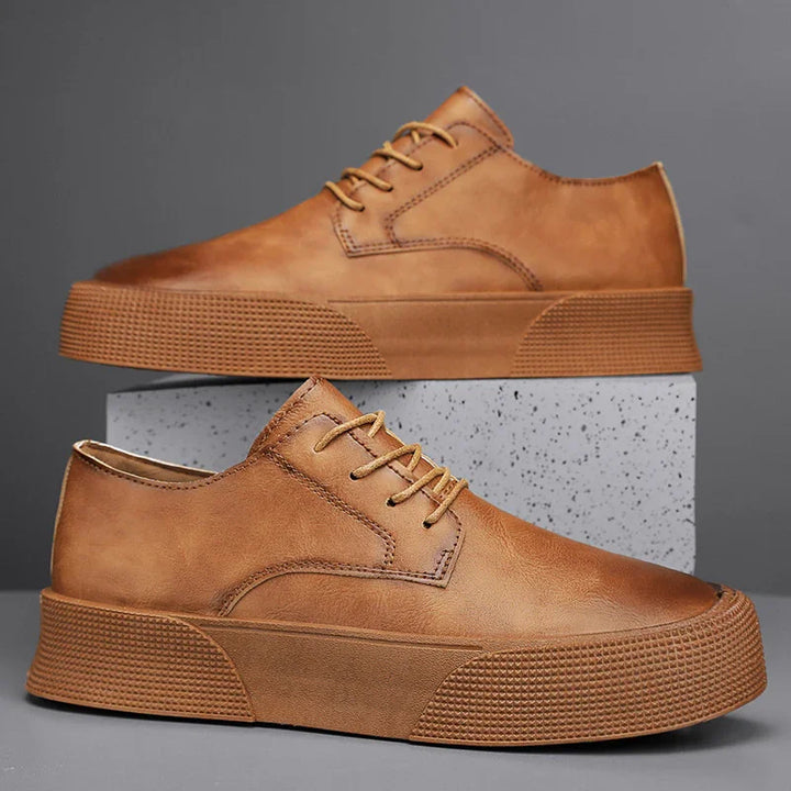 Brown leather platform sneakers with textured rubber sole on gray background