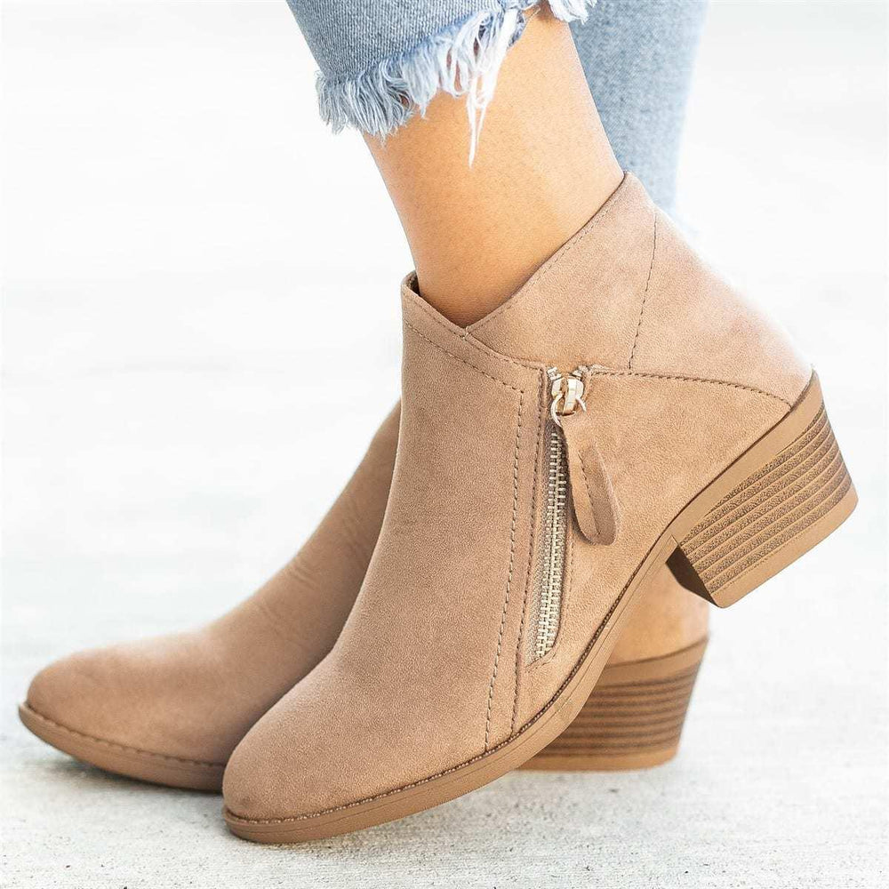 Women's beige suede ankle boots with side zipper and low stacked heel worn with frayed hem jeans