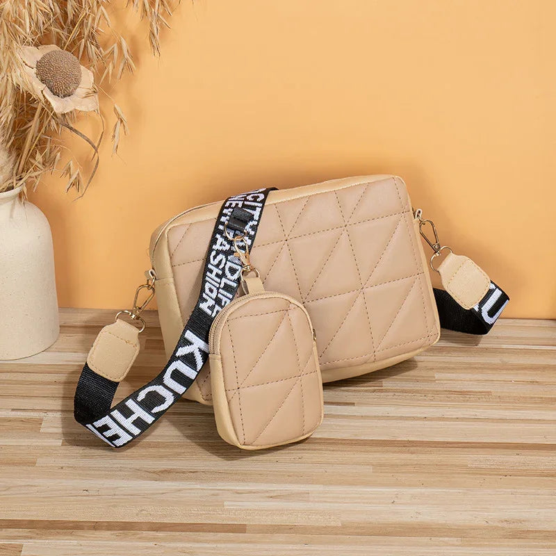 Beige quilted crossbody bag and small pouch with black and white adjustable strap on wooden surface