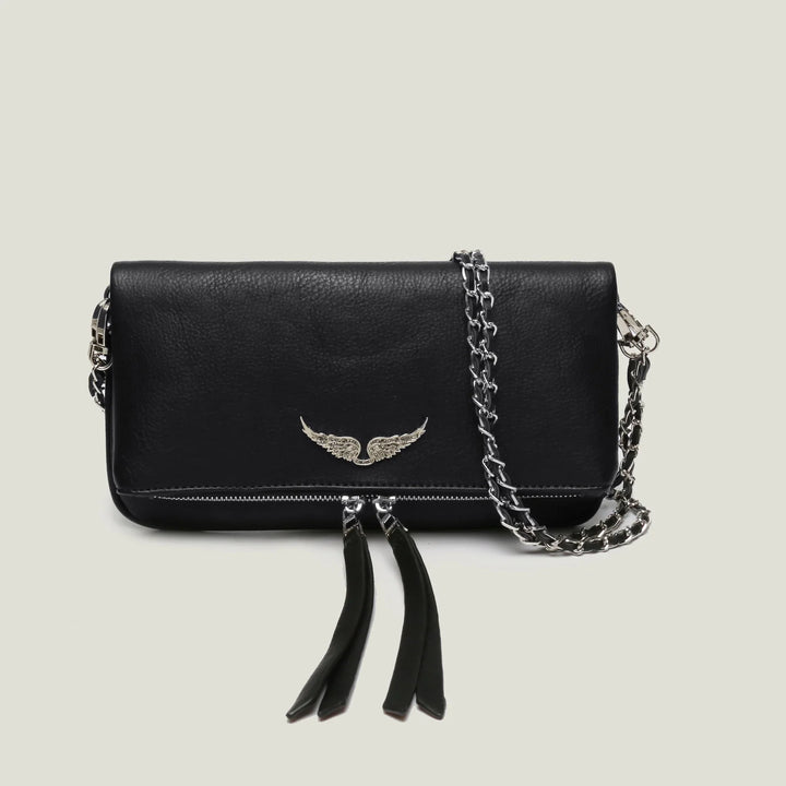 Black leather crossbody bag with silver wing emblem and chain strap on light background