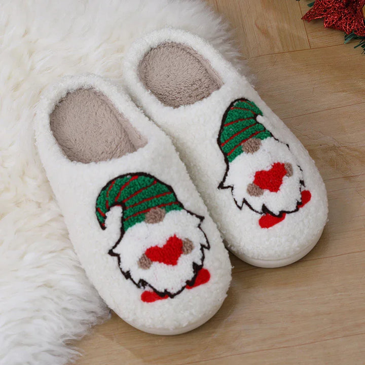 White fuzzy Christmas slippers with green and red gnome face design on wooden floor