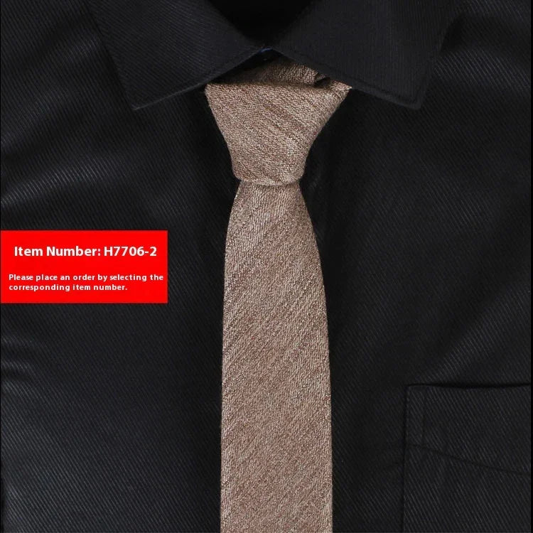 Beige textured necktie on black dress shirt with pointed collar and chest pocket