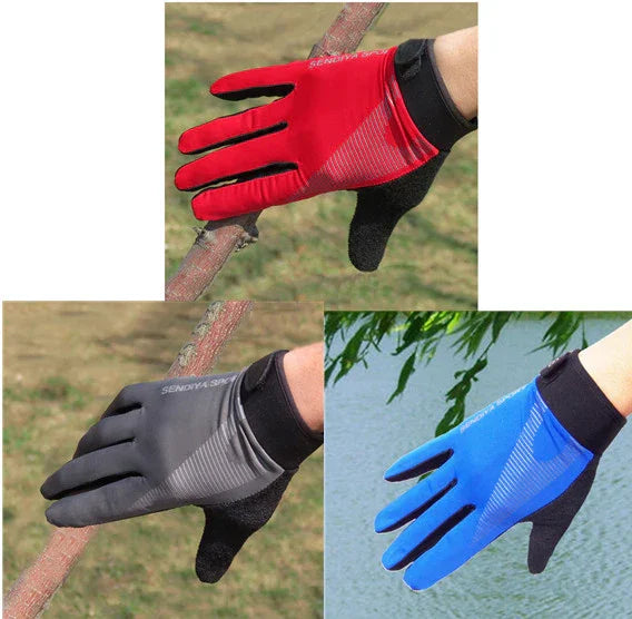 Three sport gloves in red, black, and blue worn on hands holding tree branches outdoors