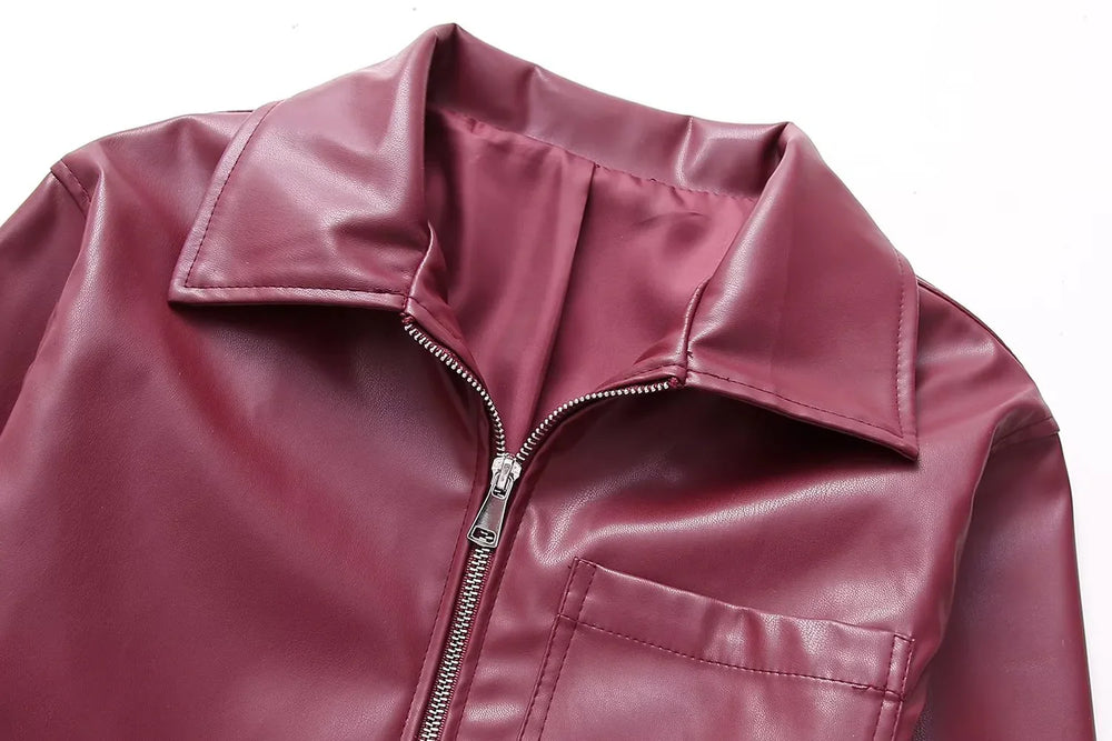 Close-up of maroon faux leather jacket with zipper and collar on white background