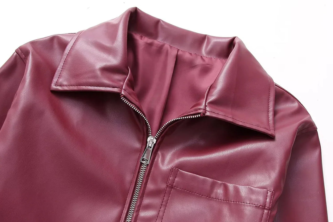 Close-up of maroon faux leather jacket with zipper and collar on white background