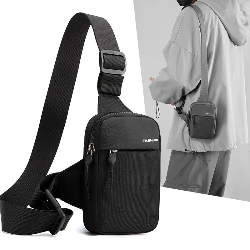 Black compact crossbody bag with adjustable strap, labeled FASHION, worn by person in gray jacket