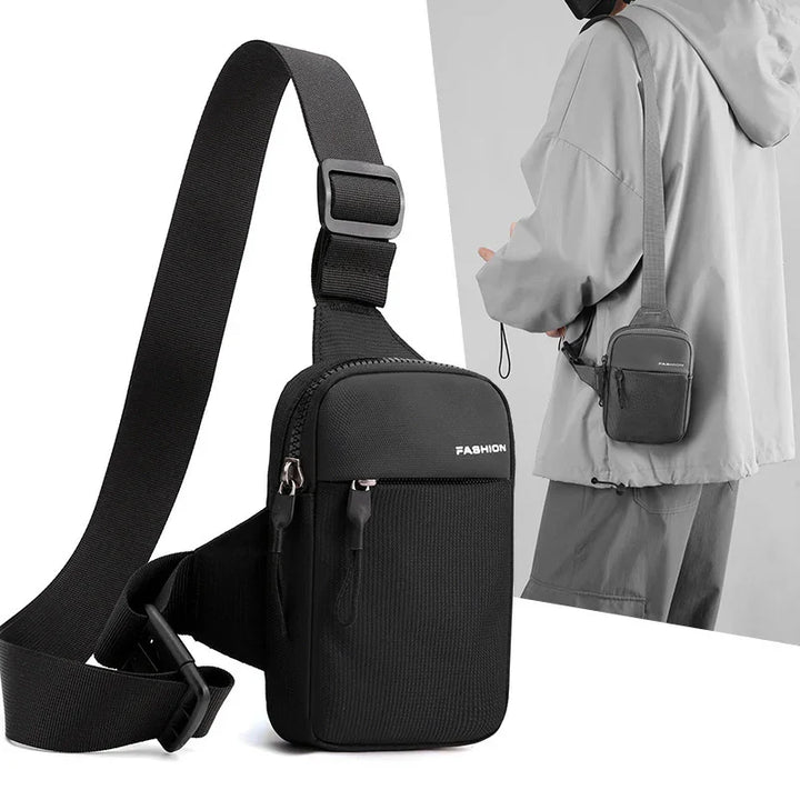 Black compact crossbody bag with adjustable strap, labeled FASHION, worn by person in gray jacket