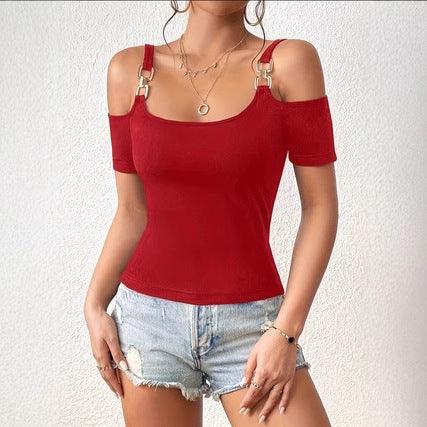Woman wearing a stylish red cold shoulder top with gold buckle straps and denim shorts