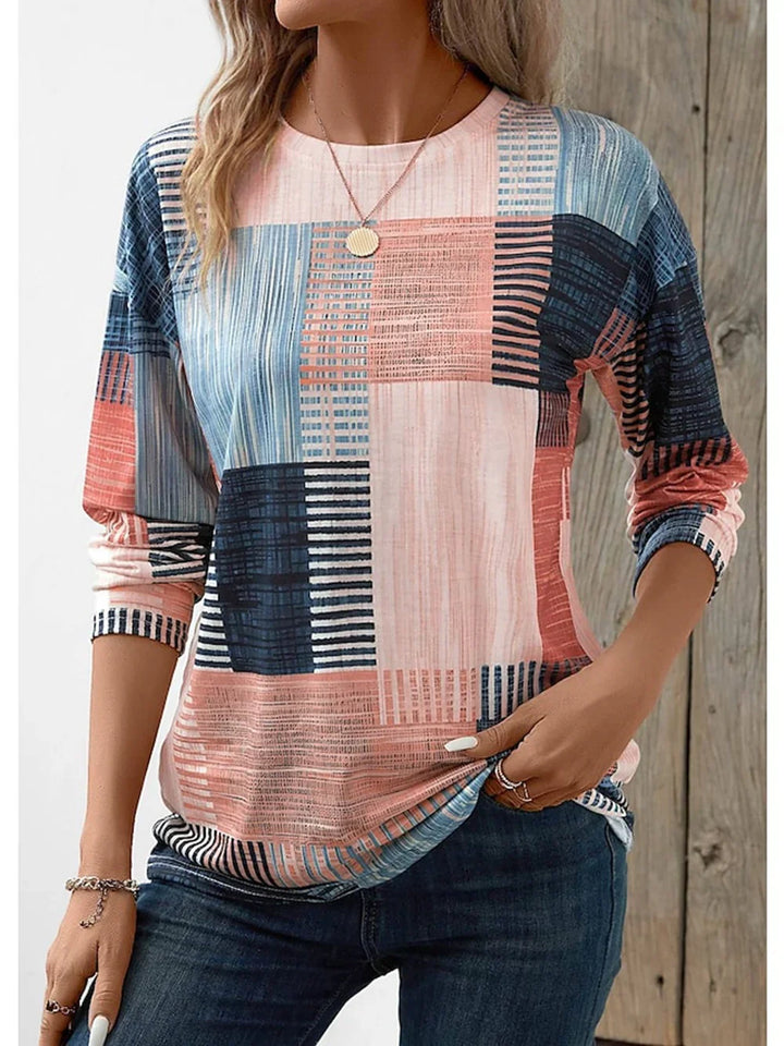 Woman wearing multicolor patchwork long sleeve casual top with jeans and jewelry
