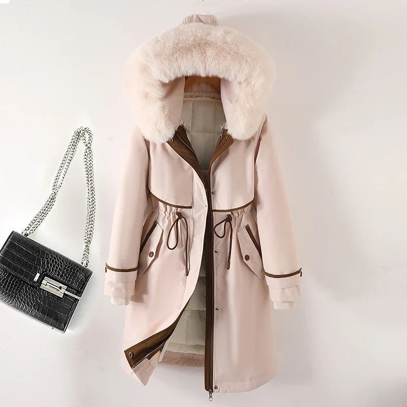 Beige winter coat with faux fur hood and brown trim, paired with black crocodile handbag with silver chain