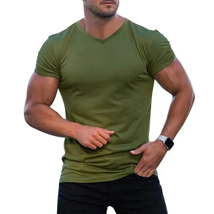 muscular man wearing fitted olive green V-neck t-shirt and black pants with smartwatch