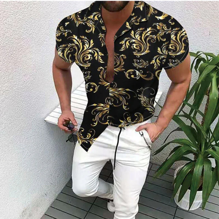 Man wearing black short-sleeve shirt with gold baroque patterns and white pants in outdoor setting