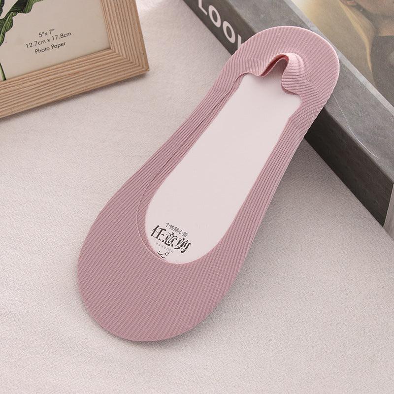 Single pink ribbed no-show liner sock for women on light fabric background