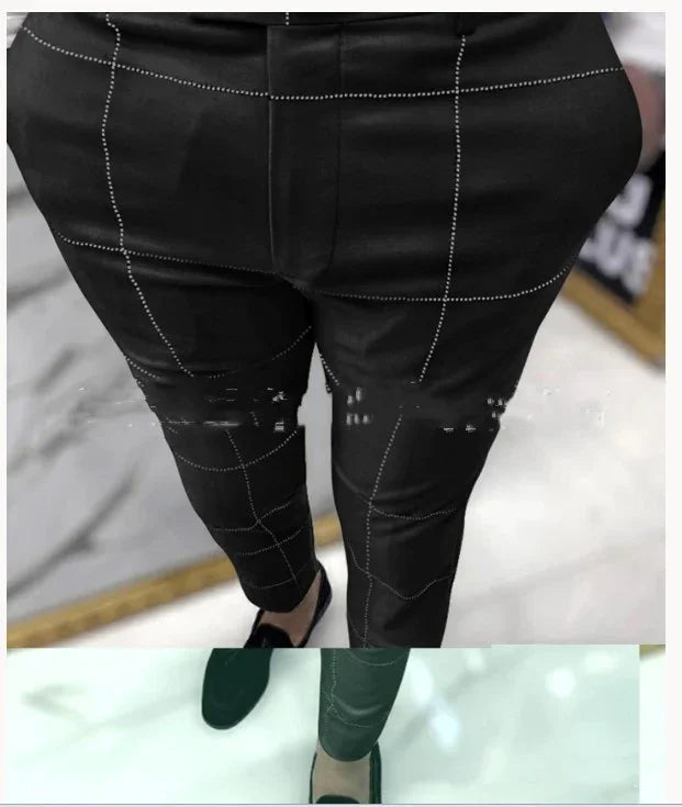 Close-up of black pants with white grid pattern worn with black slip-on shoes on marble floor