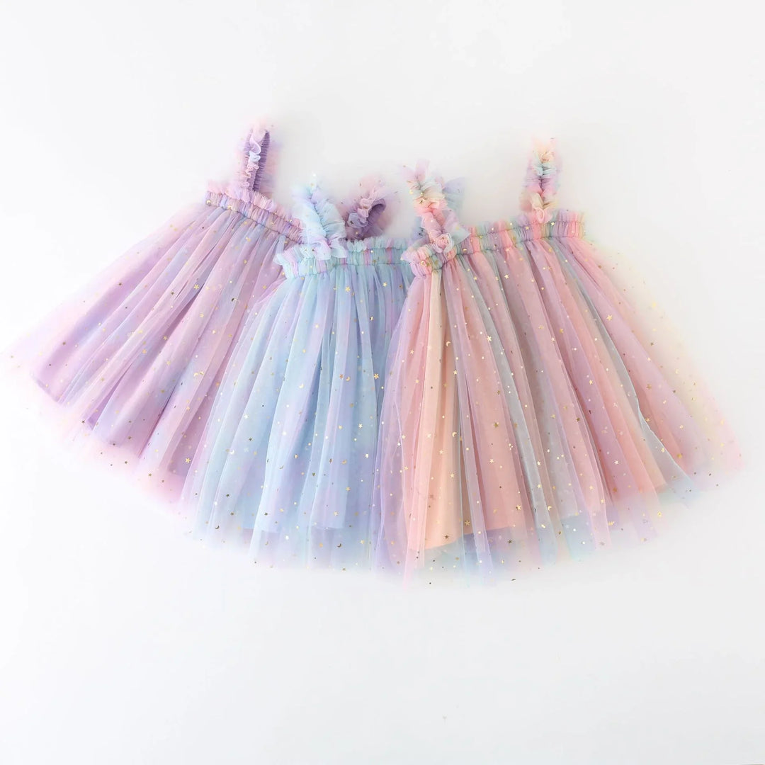 Three pastel tulle dresses with ruffled straps and gold star accents in purple, blue, and pink