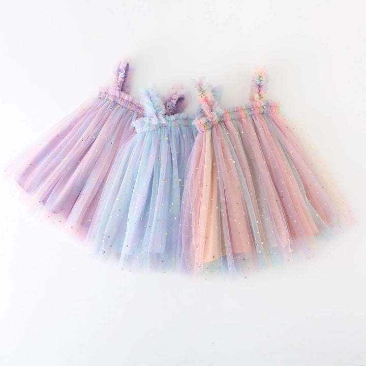 Three pastel tulle dresses with ruffled straps and gold star accents in purple, blue, and pink
