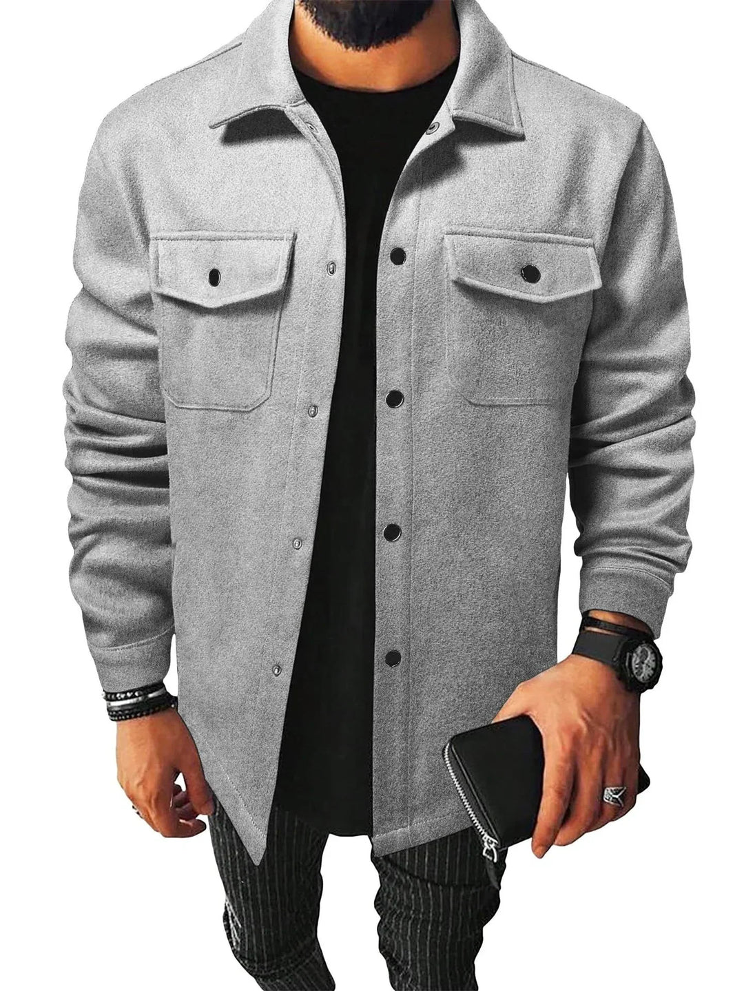 Man wearing grey button-up shirt jacket with black snap buttons over black shirt and striped pants, holding black wallet