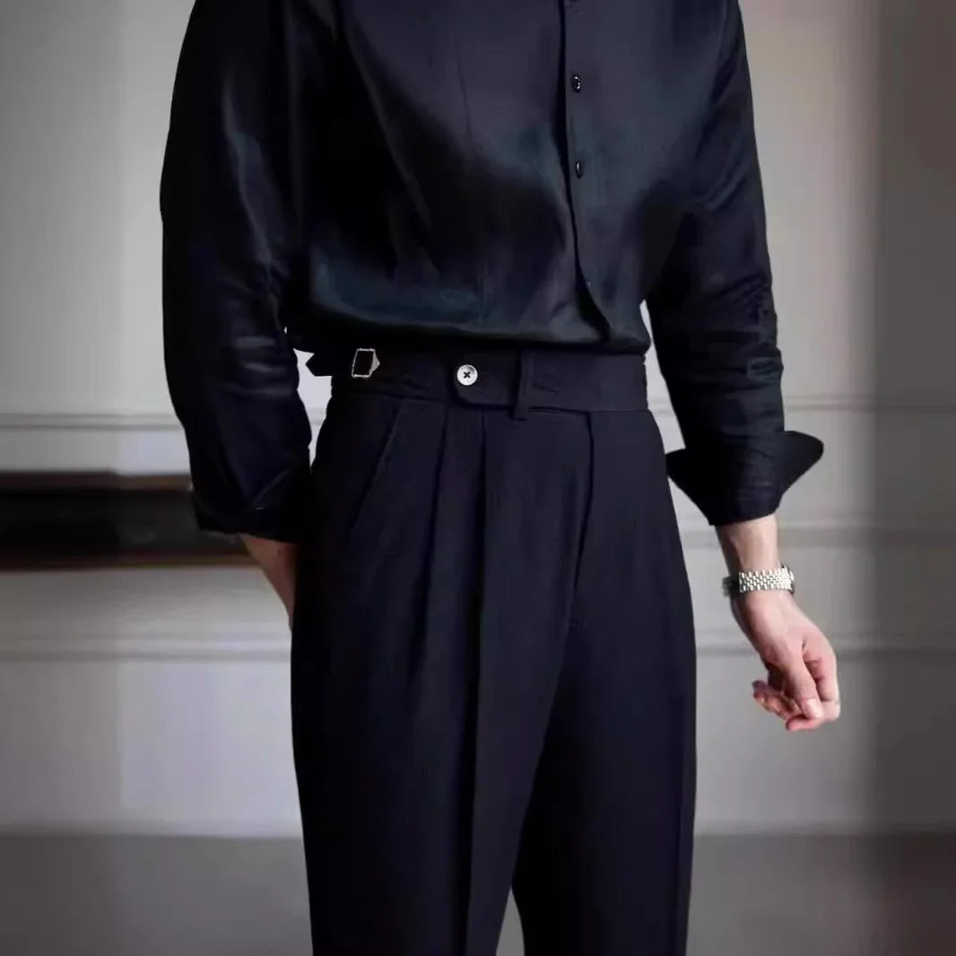 Person wearing black satin long-sleeve shirt with black tailored high-waisted pants and silver watch