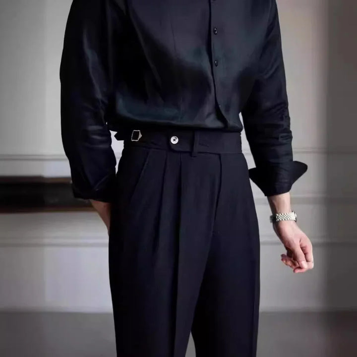 Person wearing black satin long-sleeve shirt with black tailored high-waisted pants and silver watch