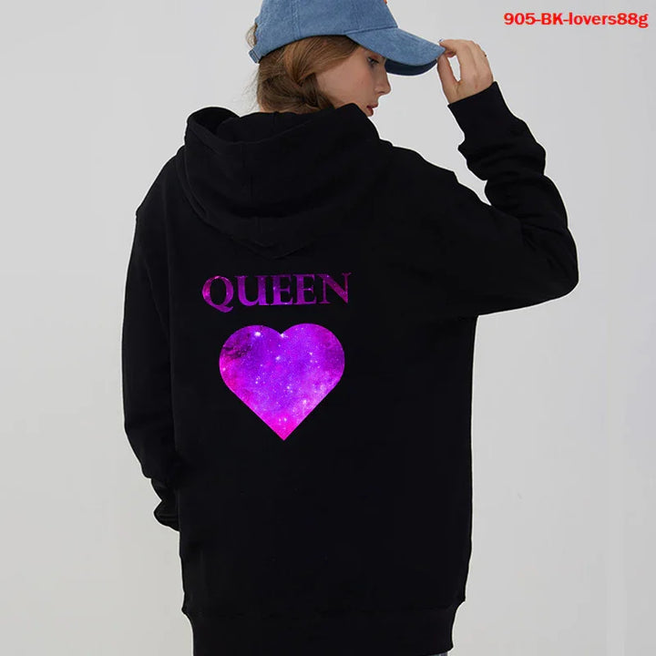 Woman wearing black hoodie with purple galaxy heart and QUEEN text on back, blue cap