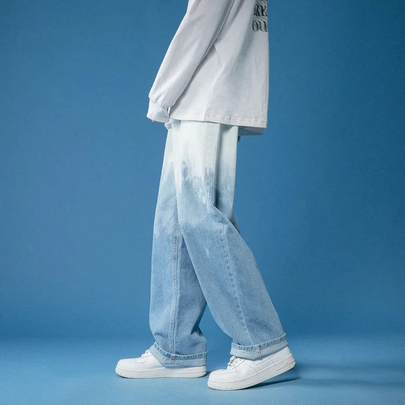 Person wearing light blue wash baggy jeans and white sneakers against blue background