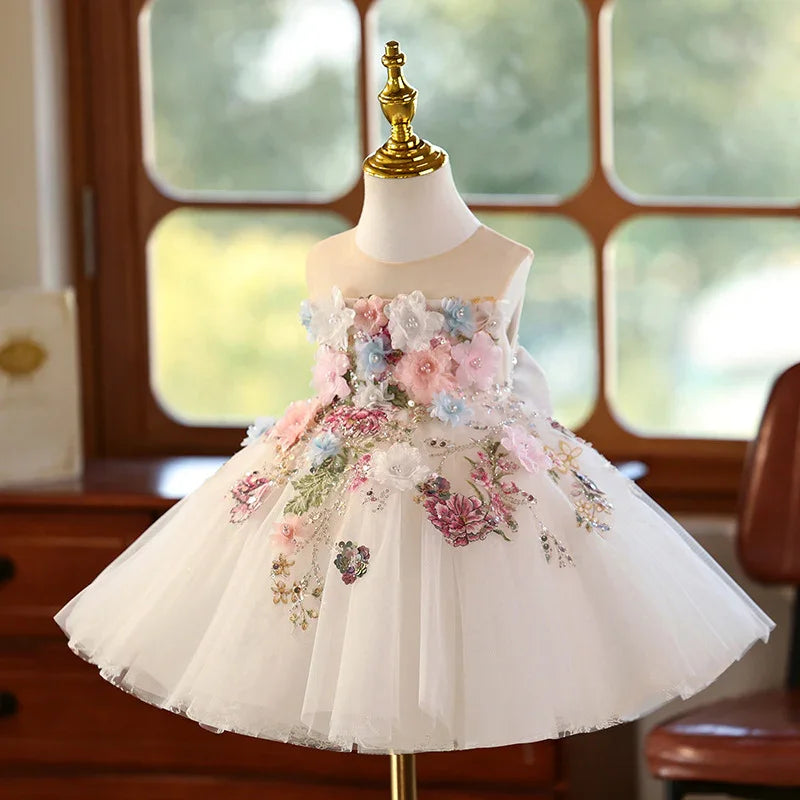 White toddler princess dress with embroidered pastel flowers on bodice and skirt displayed on mannequin