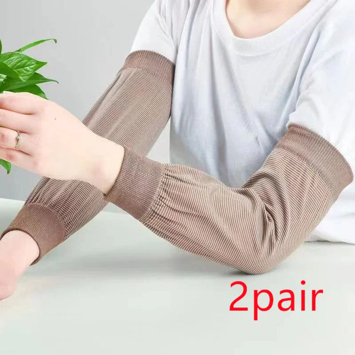 Person wearing brown striped protective arm sleeves on white shirt with green plant nearby, '2 pair' text