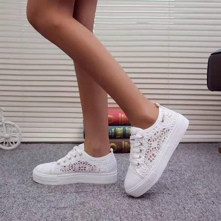 White lace women's sneakers with platform soles worn indoors on carpeted floor