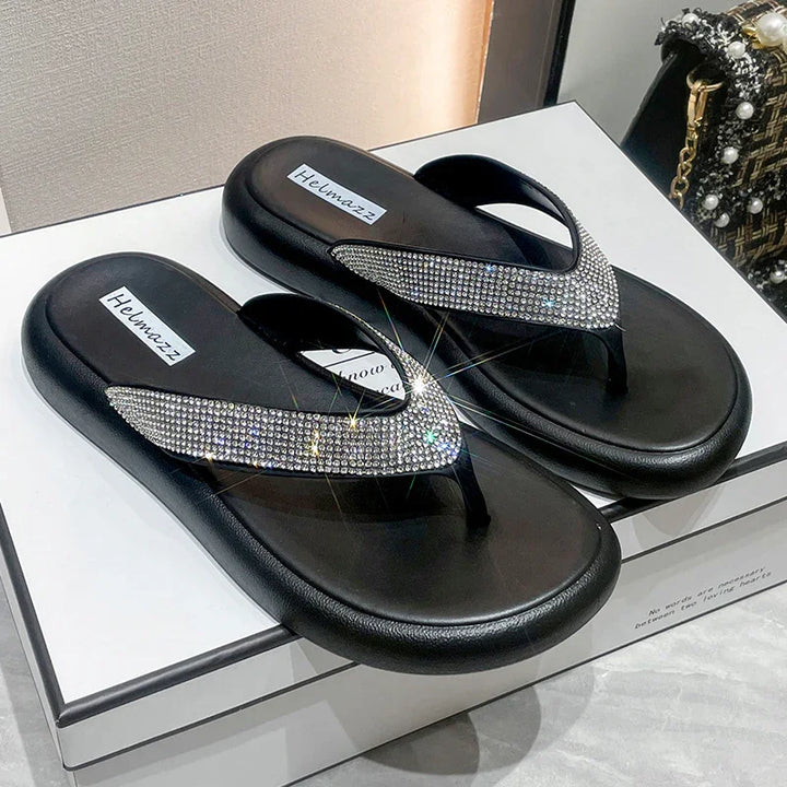 Black Helmazz flip-flops with sparkling rhinestones on straps displayed on white box