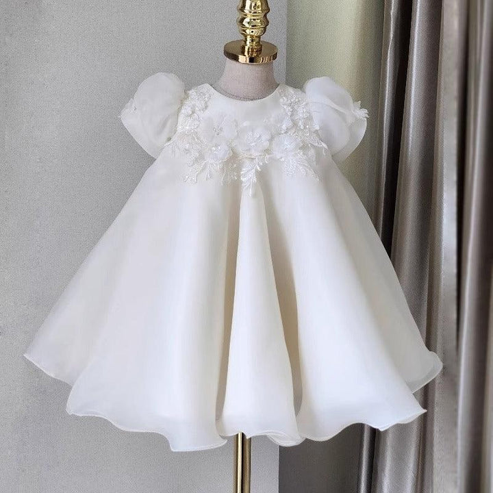 White baby dress with puff sleeves and floral lace embroidery on mannequin