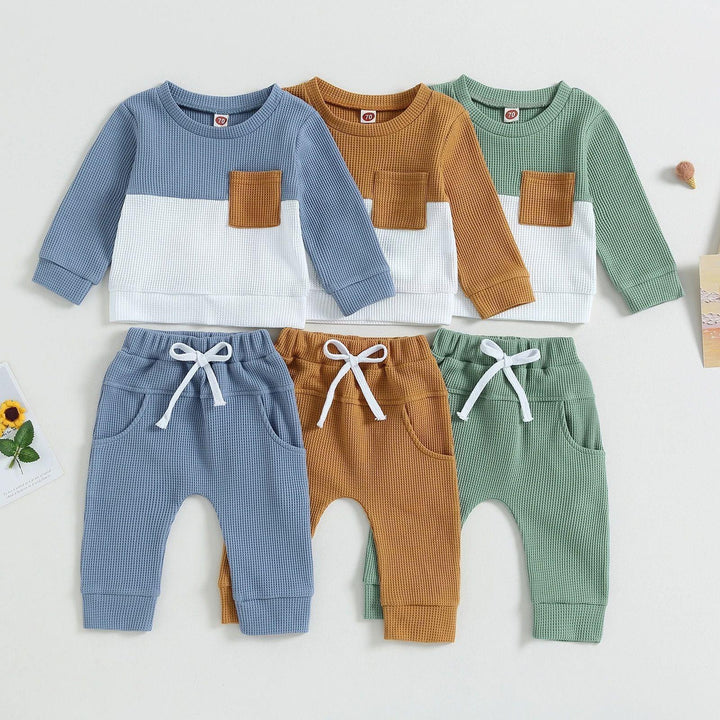 Three sets of baby waffle knit clothes with long sleeve tops and pants in blue, brown, and green colors
