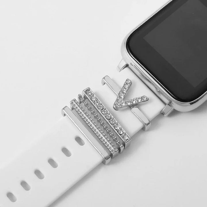 White smartwatch with silver glittery decorative charms on the band, including a V-shaped charm