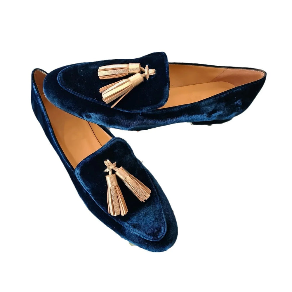 Pair of navy blue velvet tassel loafers with tan leather interior
