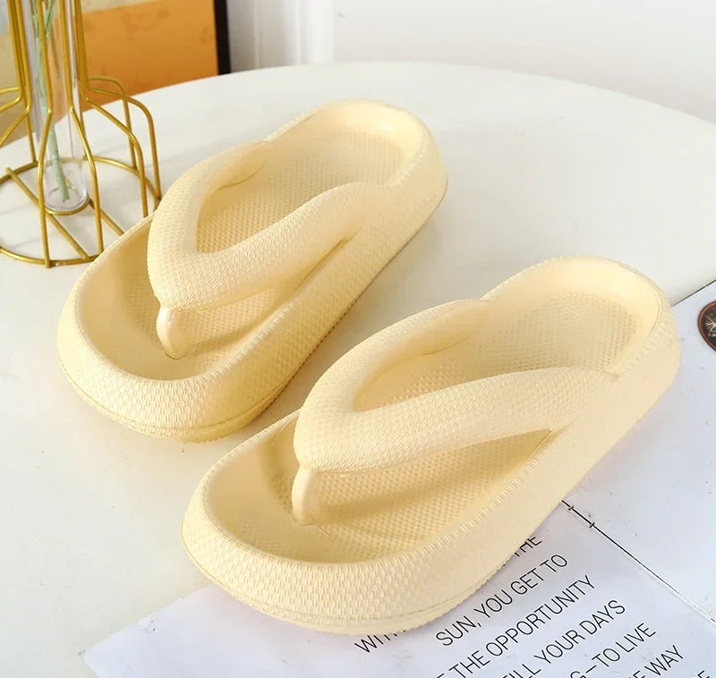Cream-colored cushioned foam flip-flop sandals on a white table with text and decorative gold wire stand