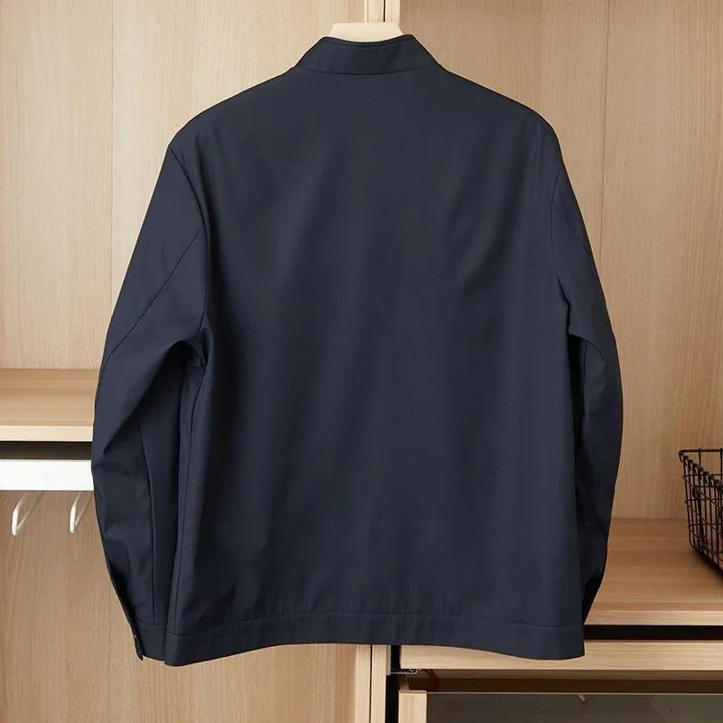 Back view of a navy blue casual jacket hanging on wooden wardrobe