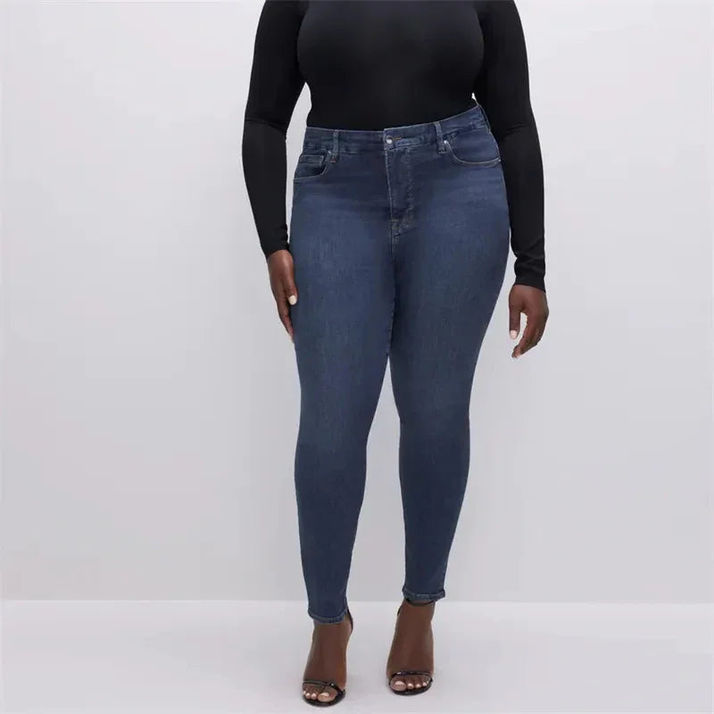 Plus size woman wearing high-waisted skinny dark blue jeans and black long sleeve top with black heels