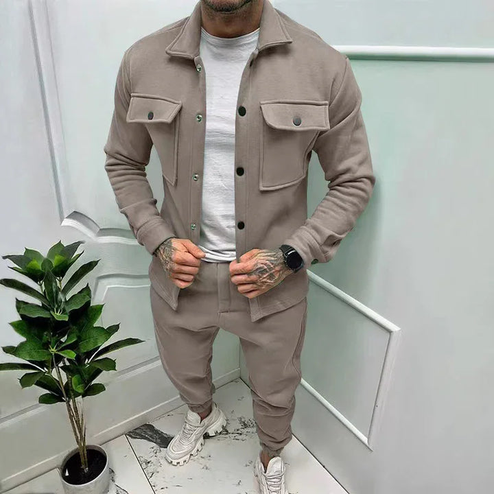 Man wearing beige button-up jacket with flap pockets and matching jogger pants in modern interior