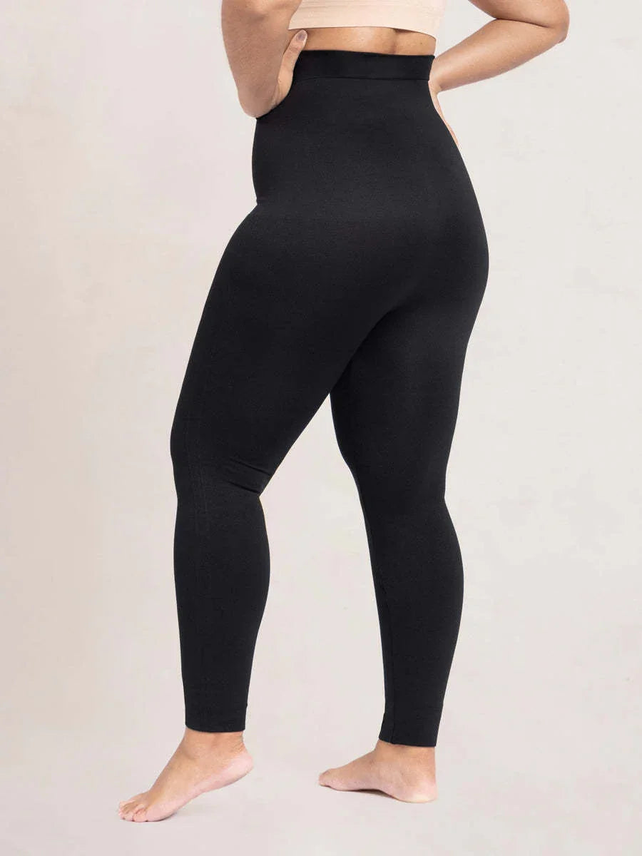Back view of person wearing high-waisted black leggings with seamless fit on neutral background