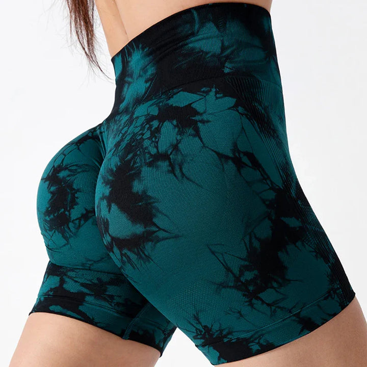 Close-up of high-waisted teal and black tie-dye seamless workout shorts on model