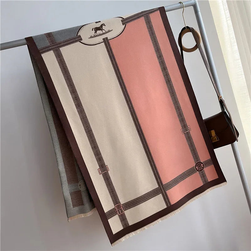 Elegant horse-themed scarf in beige and pink with brown accents hanging on a minimalist metal rack