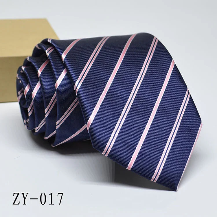 Navy blue necktie with light pink diagonal stripes, rolled and displayed on white background