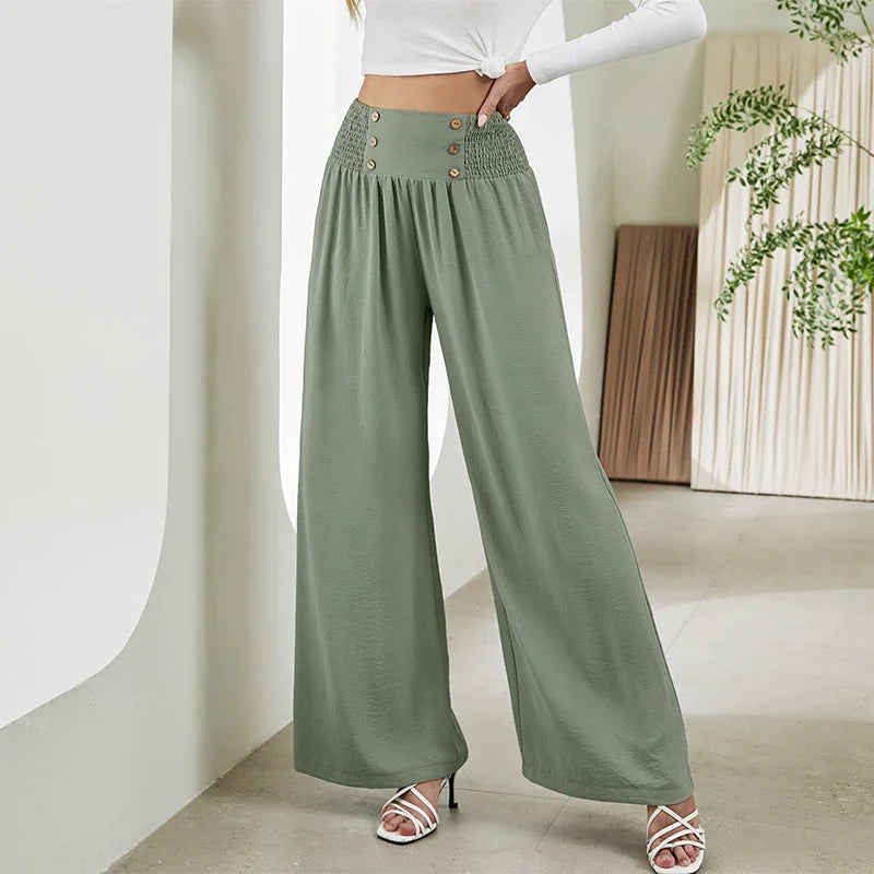 Woman wearing high-waisted olive green wide-leg pants with button details and smocked waist
