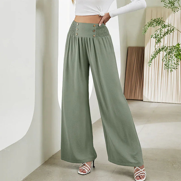 Woman wearing high-waisted olive green wide-leg pants with button details and smocked waist